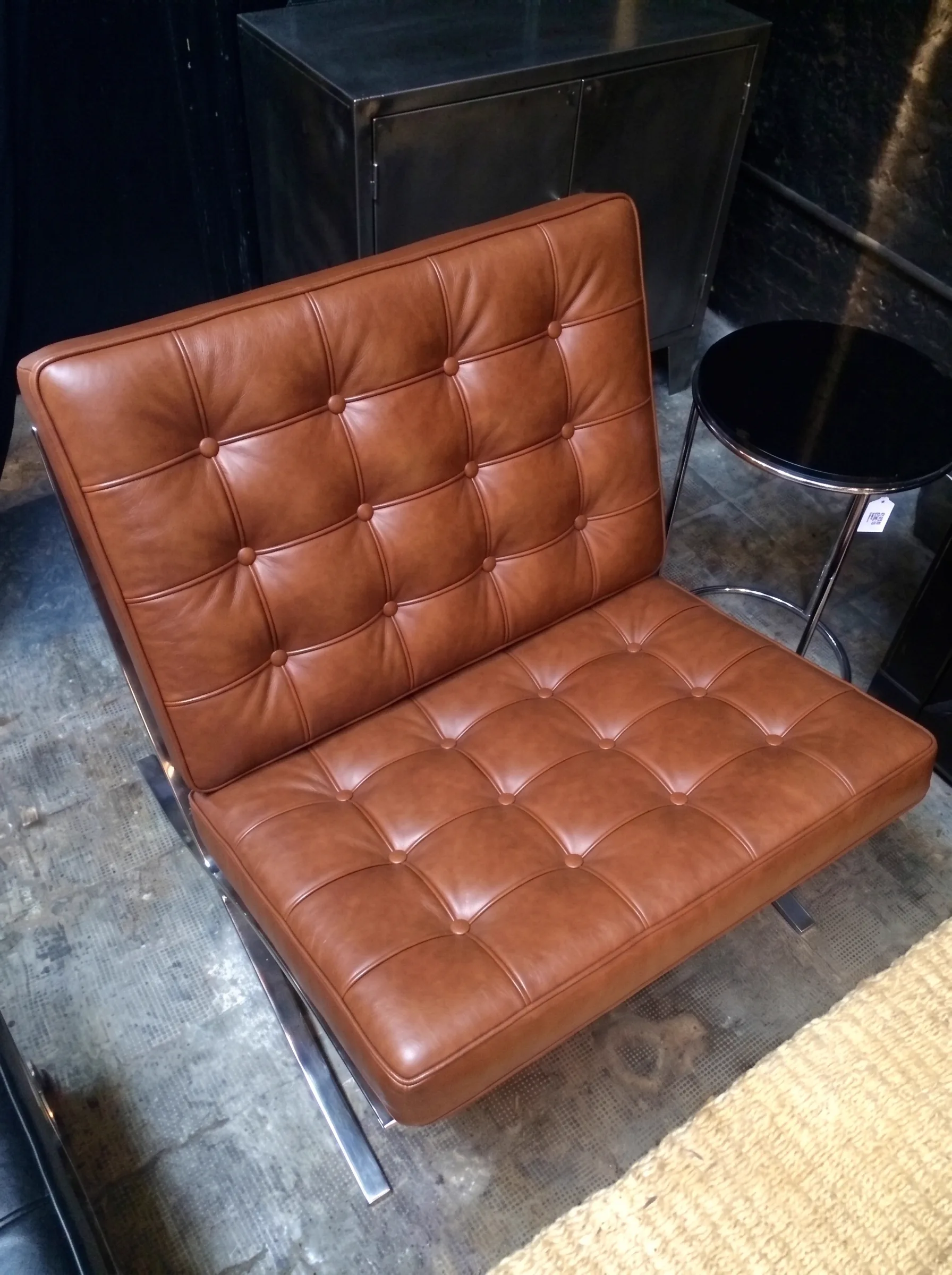 Tan button-tufted Barcelona-style lounge chair after recolour and conditioning